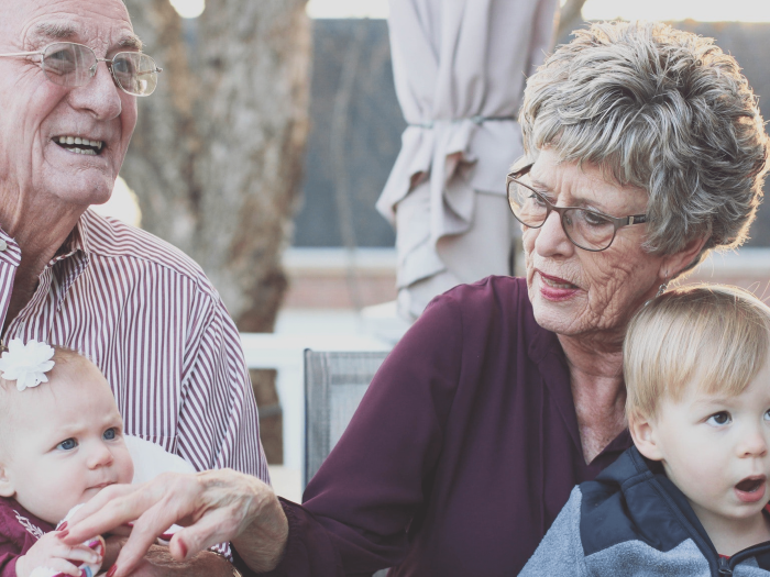 2 seniors holding 2 young children
